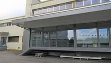 modern building, large glass windows, entrance with stairs, reception area