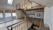 wooden floors, skylight, white walls, metal handrails, stairs, kitchen