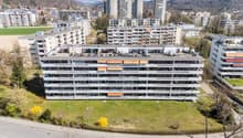 Aerial view of a multi-story residential building with multiple balconies and terraces.