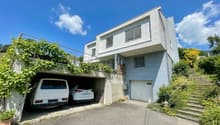 white 2 story house, garage for 2 cars, steps to the entrance, covered parking area, plants on the wall