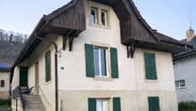 2 story house, green shutters, gable roof, wooden eaves, pathway, driveway