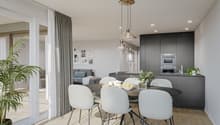 Open-concept living room and kitchen with large windows, gray curtains, round dining table with white chairs, gray sofa, black kitchen cabinets, and pendant lighting fixtures.