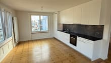 Empty kitchen with wooden floor, white cabinets, black countertops, white appliances, large windows