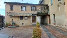 3 story house, beige stone, brown roof, balcony, garden, street lamp, plants