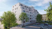 4 story apartment building, white exterior, multiple balconies, parking area, trees, shrubs