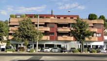 Multiple story building, cars parked in front of it