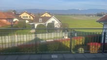 Metal railing, tiled floor, view of houses and mountains