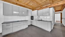 modern kitchen with white cabinets, black countertops, wooden ceiling, built-in oven, sink, faucet, dishwasher, washing machine