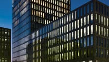 2 story office building, glass windows, metal framework, glass exterior, lit up at night