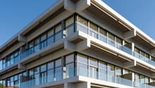 modern design, concrete structure, multiple floors, large glass windows, balconies