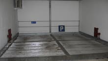 Enclosed parking space with metal racks and an Allianz sign indicating it is a parking area.