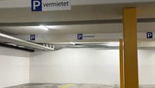 Empty parking lot with yellow lines, white walls, and yellow pillars.
