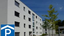 Modern apartment building, white exterior, multiple windows, parking sign
