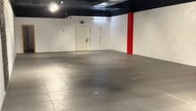 Empty room with white walls, gray floor, two doors, and a red pillar.