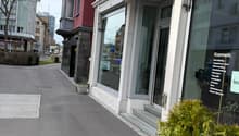 3 story building, brick and white facade, glass door and window, balcony, street sign, parking spot