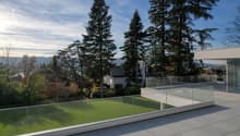 Terrace with glass railing, lush greenery, trees, panoramic view of the mountains and valley