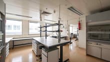 laboratory with tables, chairs, cabinets, fire extinguishers, windows, ventilation systems