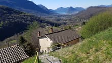 House on a hill, brown roof, yellow handrails, stone steps, mountain view