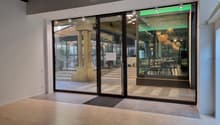 glass doors, wooden floor, white walls, plants, tables, chairs, lamps