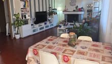 Dining room with dining table, chairs, fireplace, TV, shelves, plants, chandelier