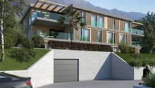 A two-story modern house with balconies, glass windows, and a concrete wall; with trees and a mountain in the background.