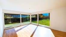 large windows, wooden floor, white walls, view of a garden