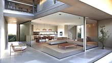 Open-concept living space with large windows, modern kitchen, dining area, and living room. Sliding glass doors lead to an outdoor terrace or balcony area.