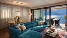 turquoise sofa, wooden table, dining chairs, glass doors, balcony, lake view