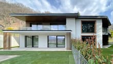 Modern house, white exterior, large glass windows, balcony, wooden fence, well-maintained lawn