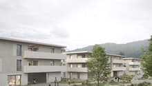 Modern apartment building, multiple floors, balconies, open green spaces, walking paths, trees, distant mountain