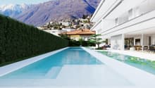 Modern house with a large swimming pool, surrounded by a lush garden and overlooking a mountainous landscape. The house has a sleek, white exterior with large windows and a terrace.