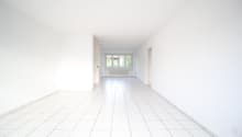 Empty room with white walls and floor, two doors, window with white radiator