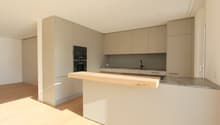 Open kitchen with granite countertop, built-in oven, island counter with wooden top, stainless steel faucet, modern cabinets