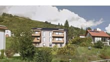 3-storey apartment building on hill, surrounded by greenery, large windows