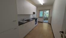 modern kitchen, white cabinets, black countertops, stainless steel sink, gas stove, oven, balcony