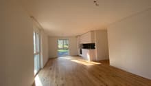 Empty room, wooden floor, white walls, windows, open to the kitchen