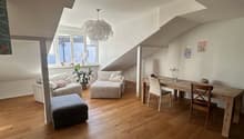 open space with wooden floor, white walls, large windows, dining table, chairs, sofa, ottoman, potted plant, chandelier
