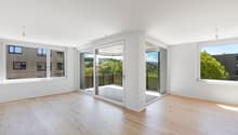 Open floor plan, wooden flooring, large windows, sliding glass doors, balcony with railing