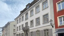 3 story building, white paint, balcony, windows, front door