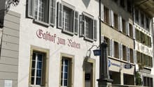 Facade of a traditional building with several windows and red lettering 'Balthor zum Raben'.