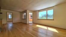 large empty room, hardwood floors, glass doors leading to balcony, large windows