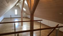 empty attic room, wooden beams, wooden floor, white walls, window, radiator