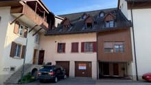 3 story house, beige and brown exterior, 2 garages, stairs, car parked