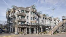 multistory residential building, many balconies, glass entrance canopy, sign reading Die Post