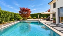Privater Pool mit grosszügiger Sonnenterrasse, eingebettet in einen gepflegten und geschützten Garten.