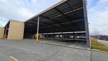 Metal roofing, columns, wide open space, paved floor, yellow road lines