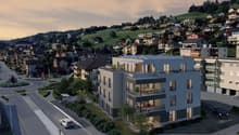 Modern apartment building with multiple floors, balconies, and a rooftop terrace.