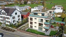 4 story building, modern style, multiple balconies, green rooftop, outdoor seating area, nearby green space