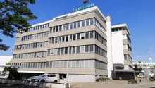 modern office building, multiple floors, glass windows, parking area in front