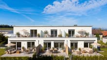 Moderne Terrassenmöblierung am weißen Wohnhaus